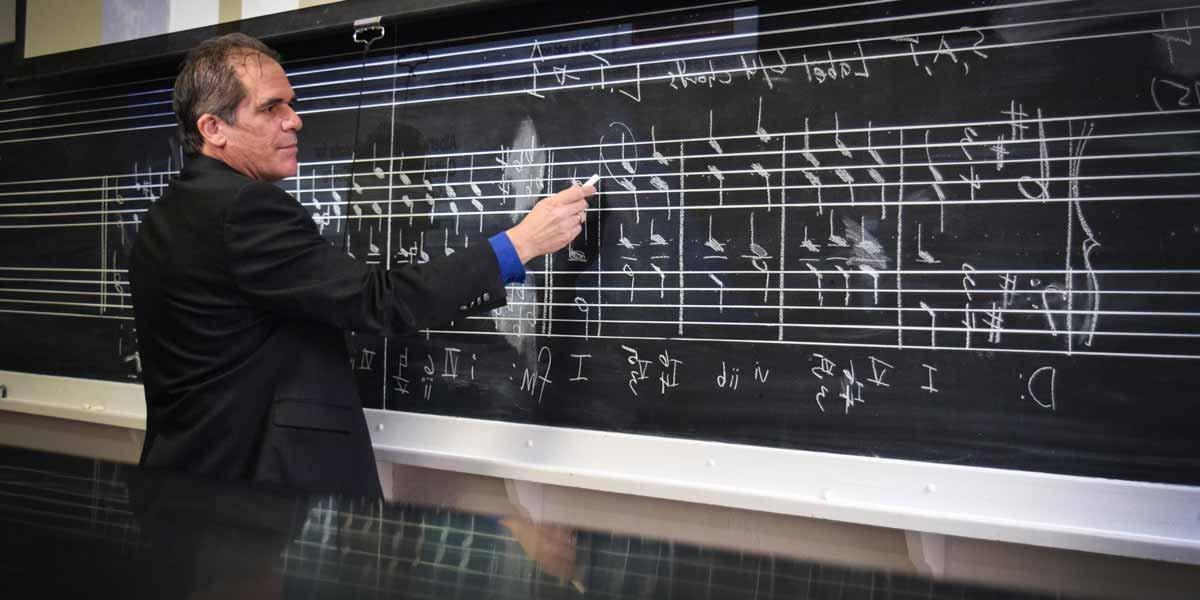 Dr. Christopher Greco teaches music at the blackboard